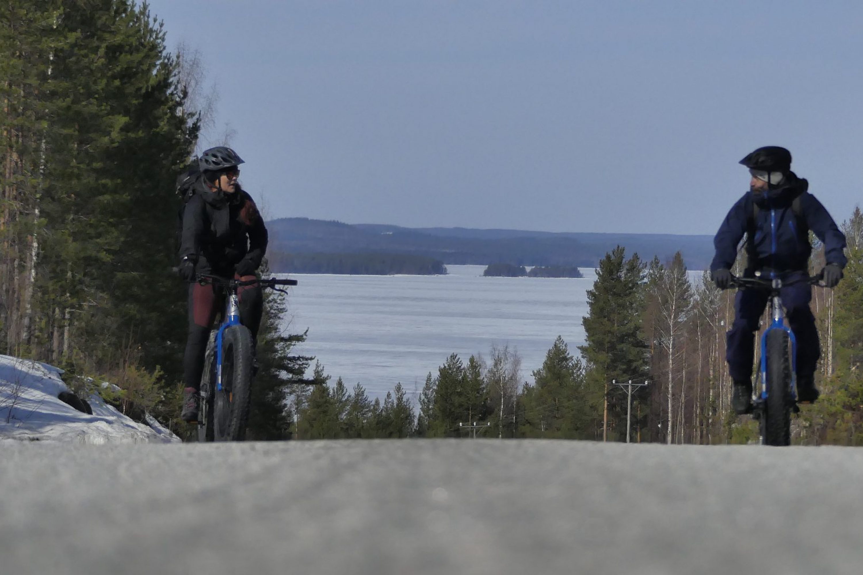 Kaksi pyöräilijää keväisissä maisemissa