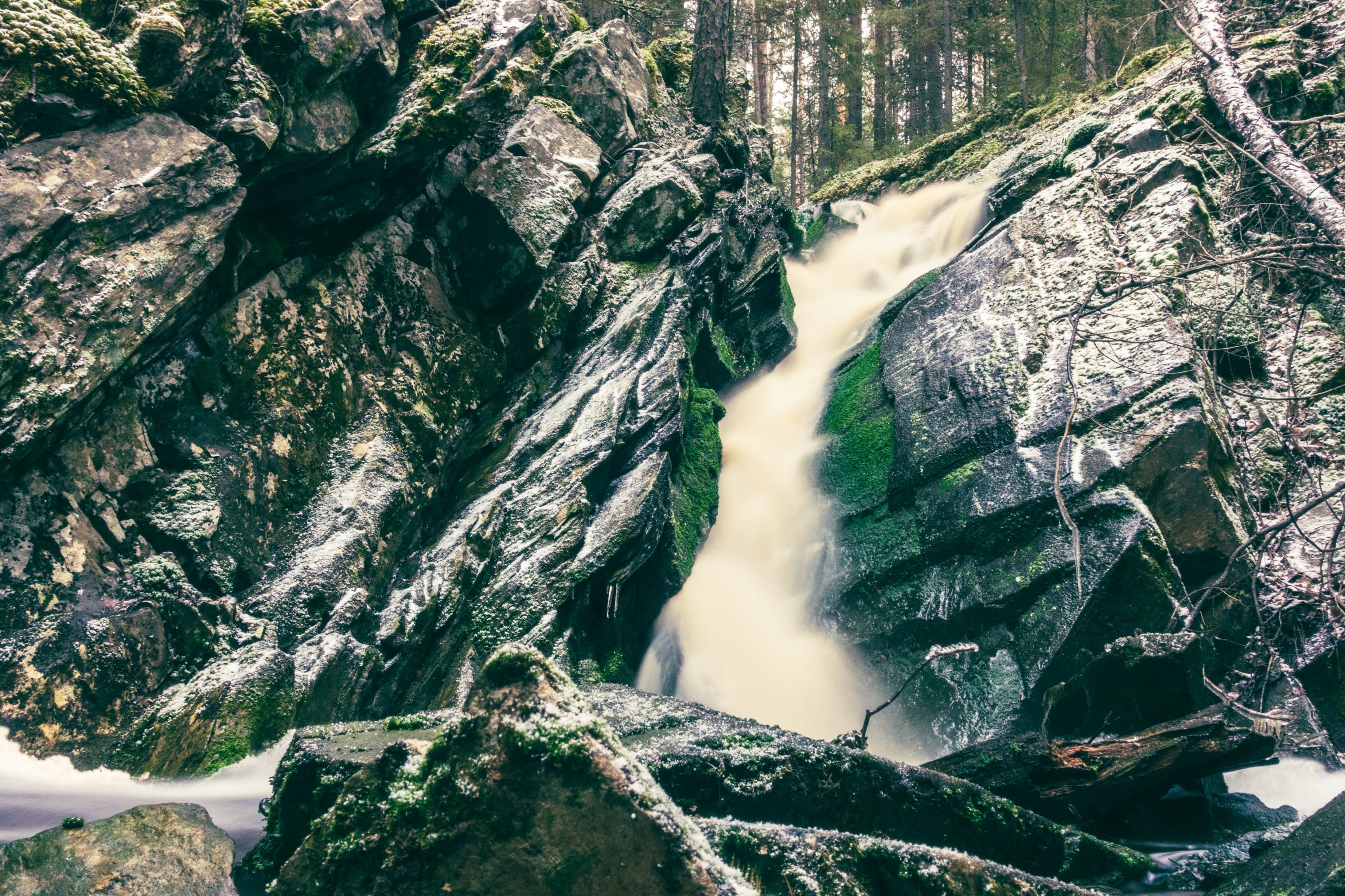 Pieni vesiputous talvisessa metsässä