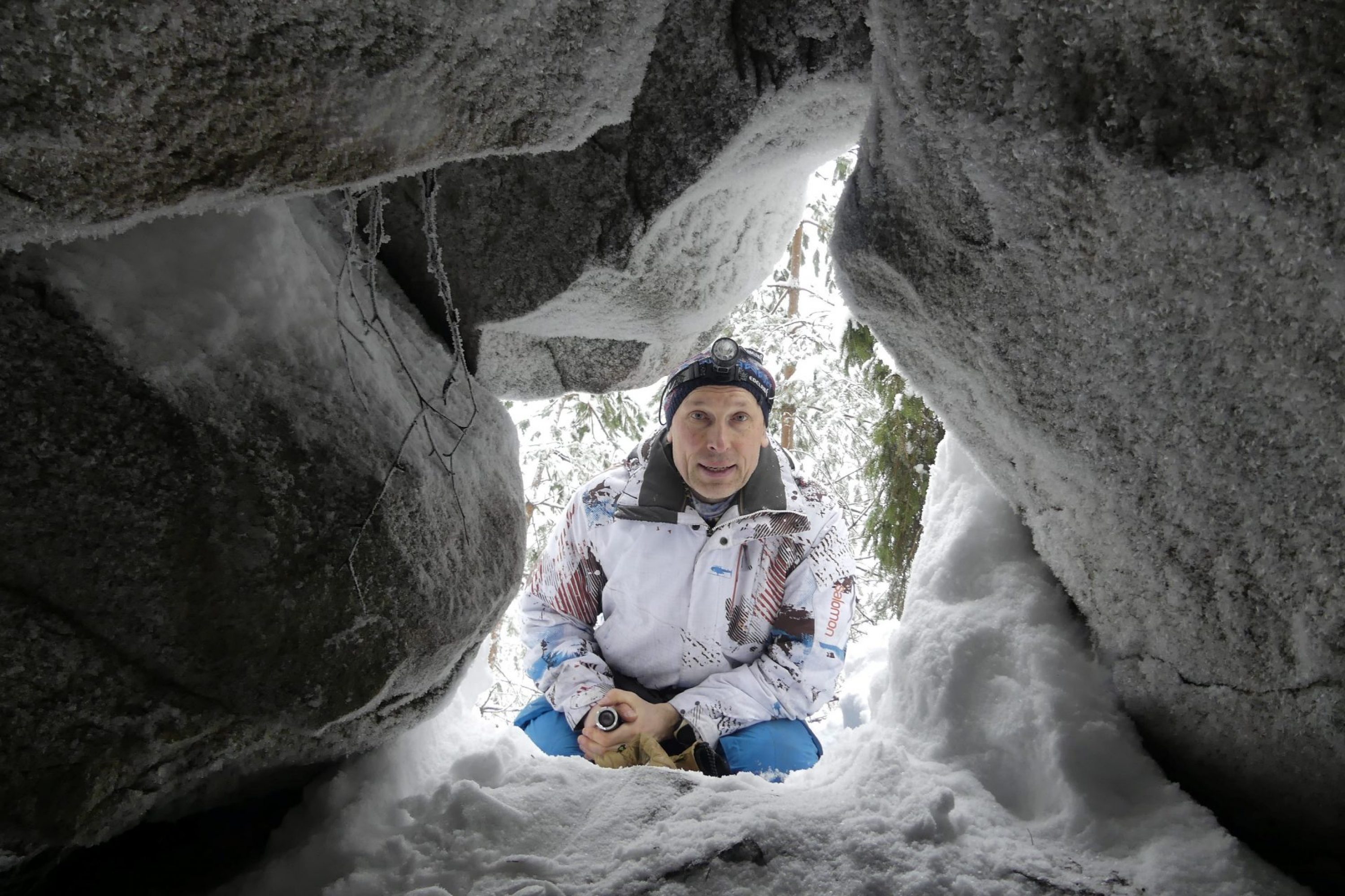 Mies kurkistaa luolan suulta