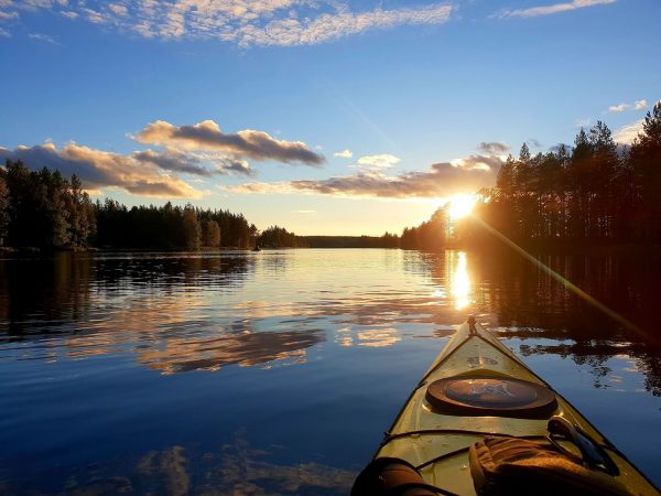 Meloja lipumassa kohti auringonlaskua tyynellä järvellä