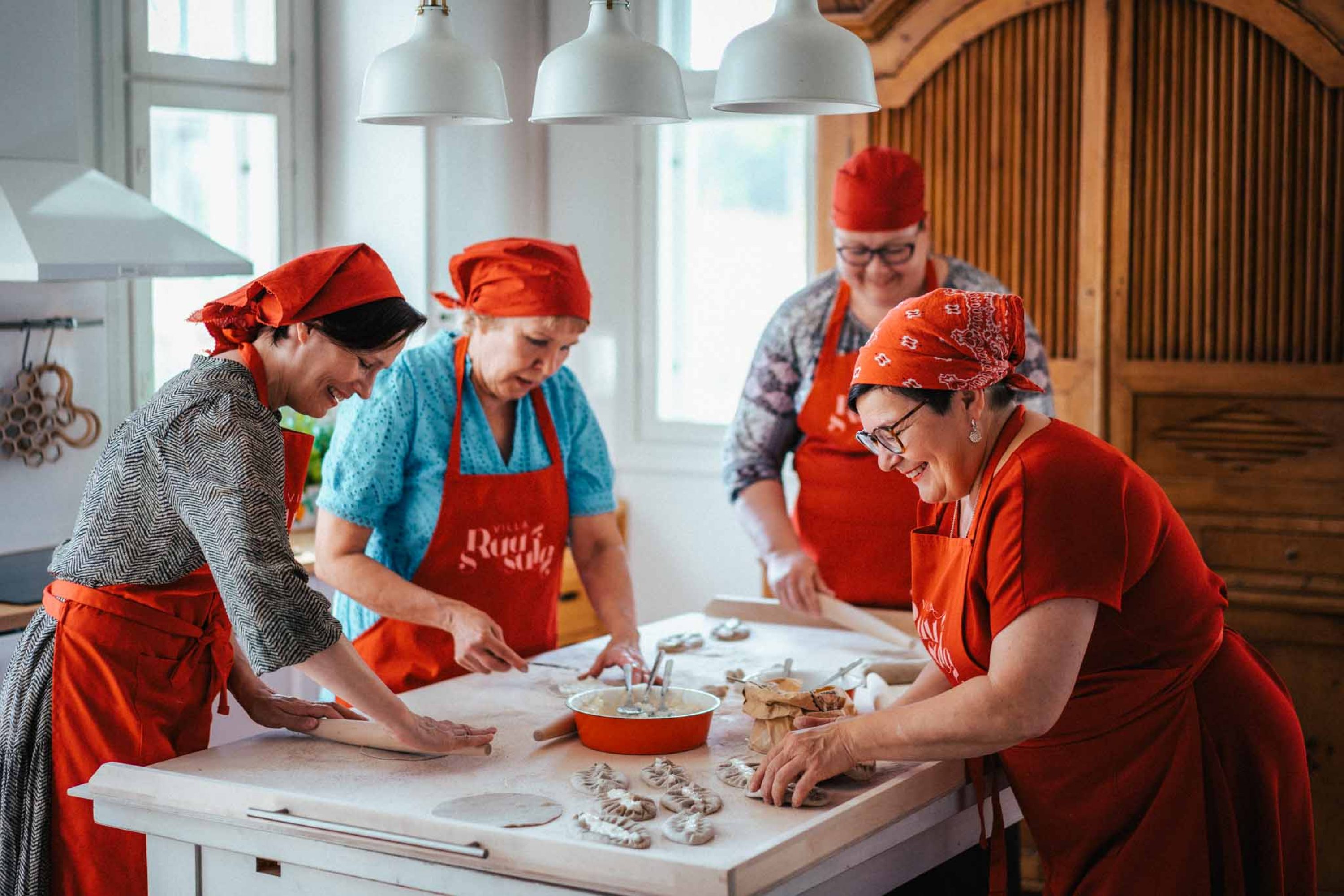 Karjalaiset emännät leipomassa karjalanpiirakoita