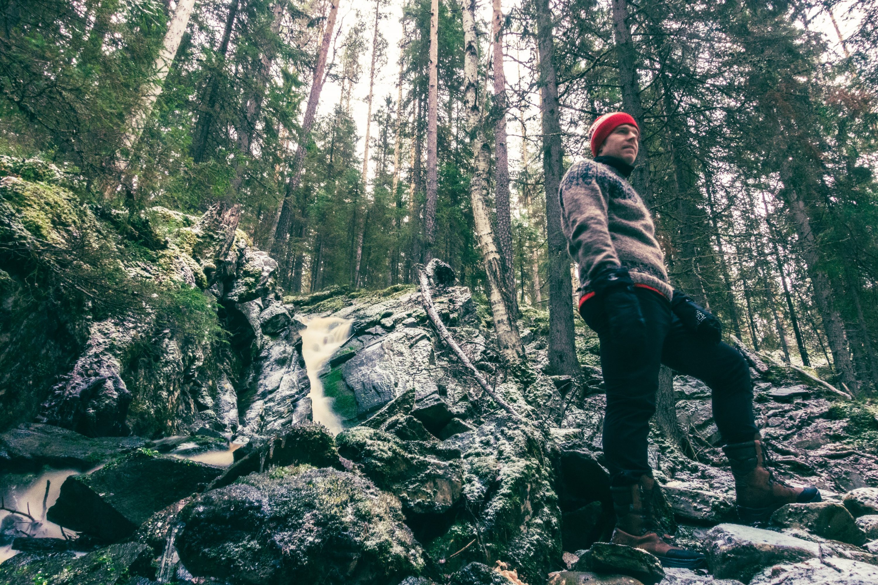 Mies seisoo talvisessa metsässä