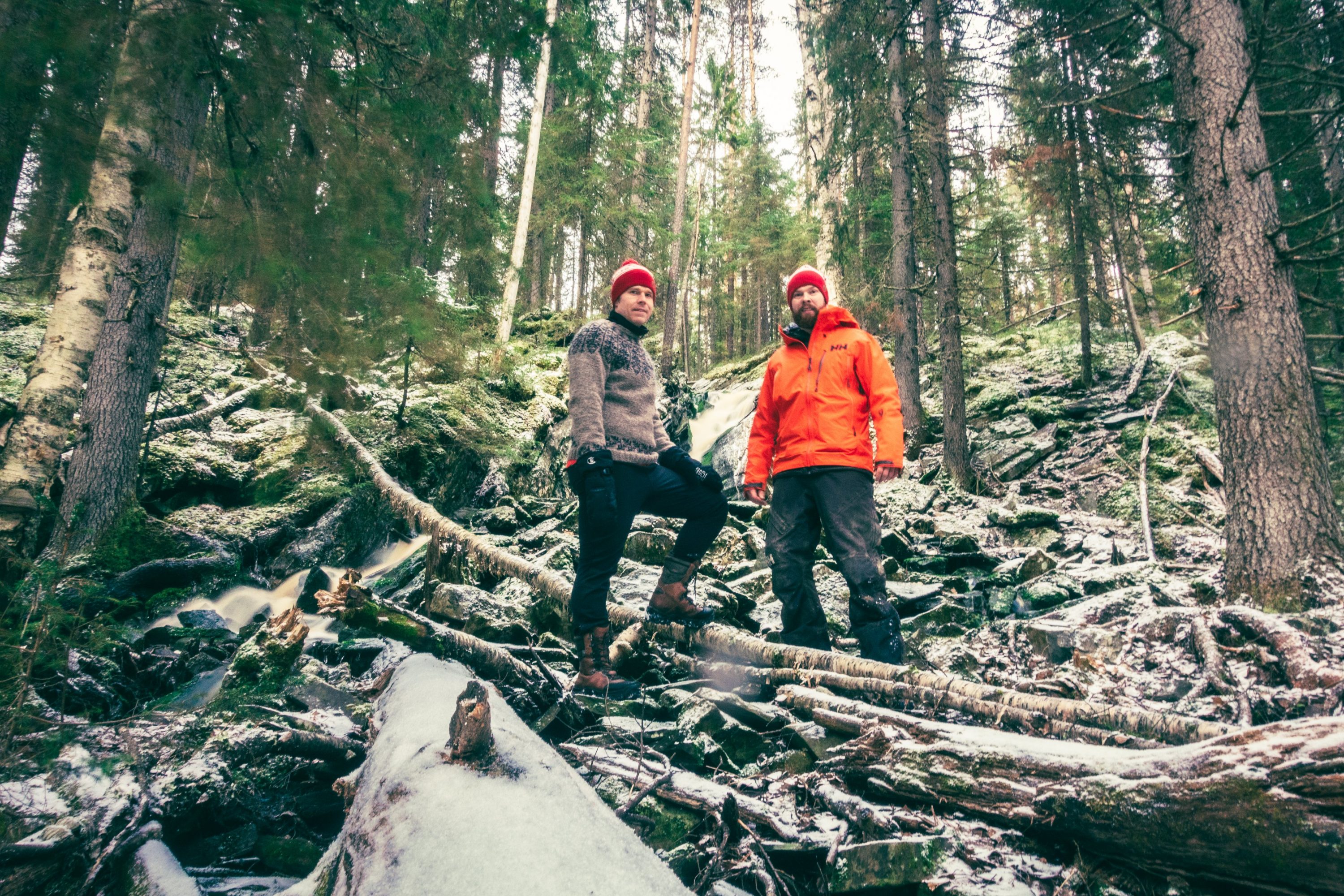 Kaksi miestä seisoo talvisessa metsässä