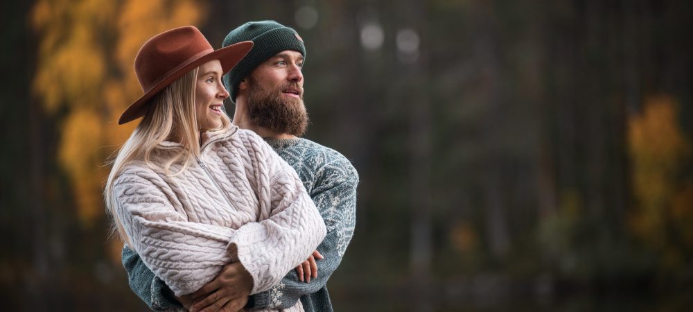 Pariskunta syleilee toisiaan lammen rannalla
