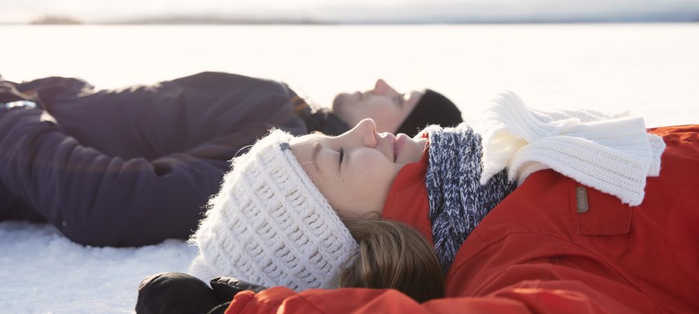 Mies ja nainen makaavat selällään Pielisen jäällä