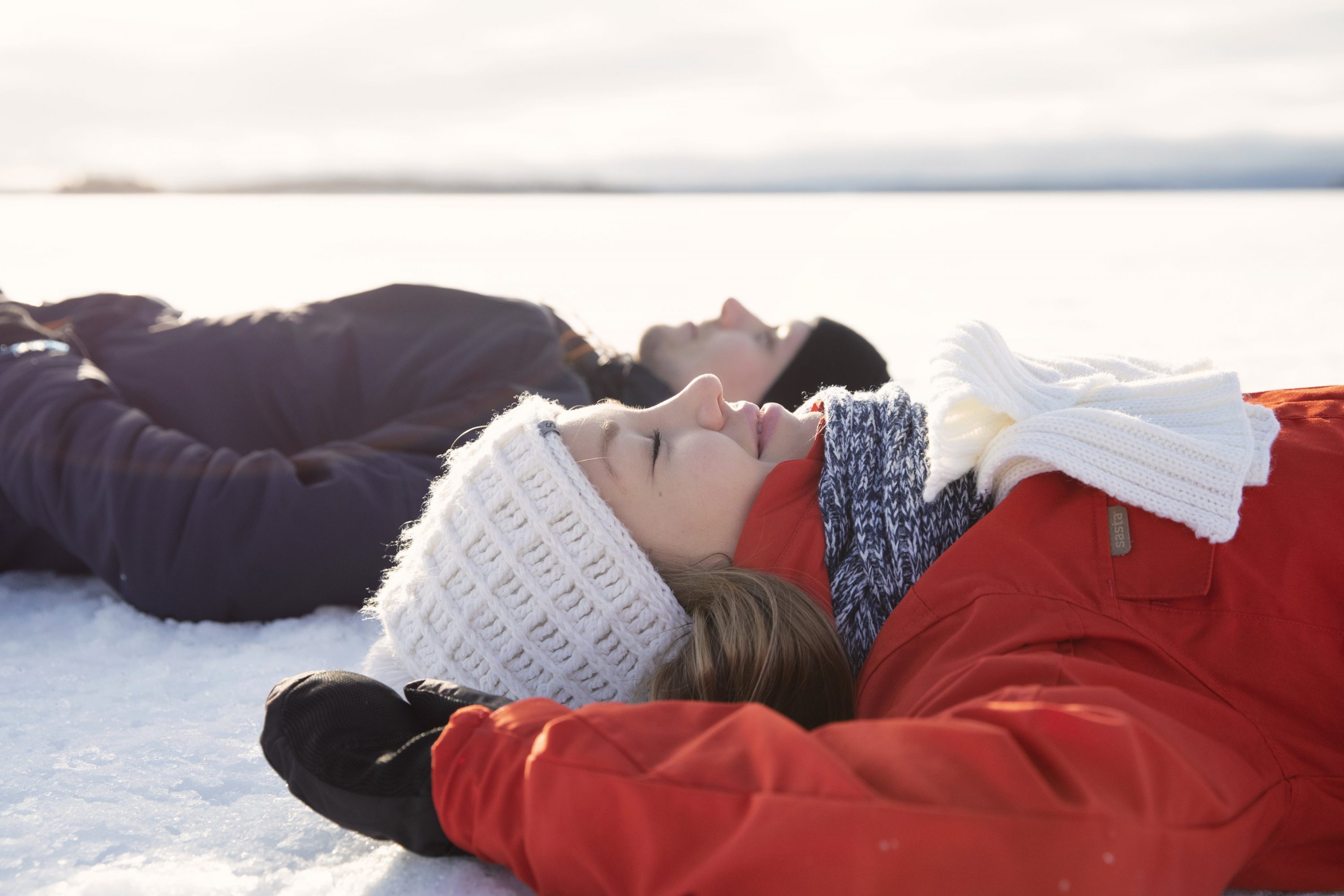Mies ja nainen makaavat selällään Pielisen jäällä
