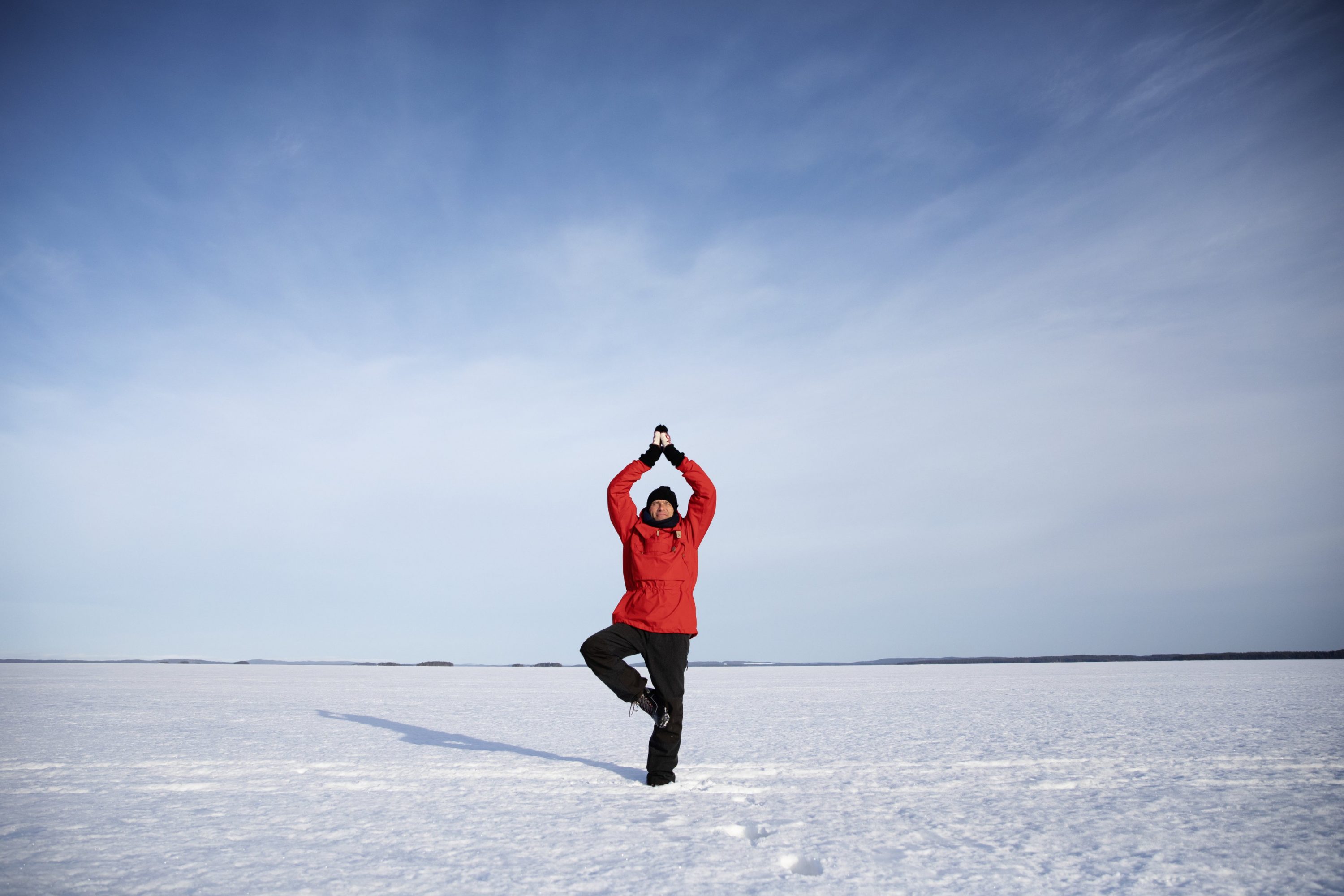 Mies meditoi järvellä talvella