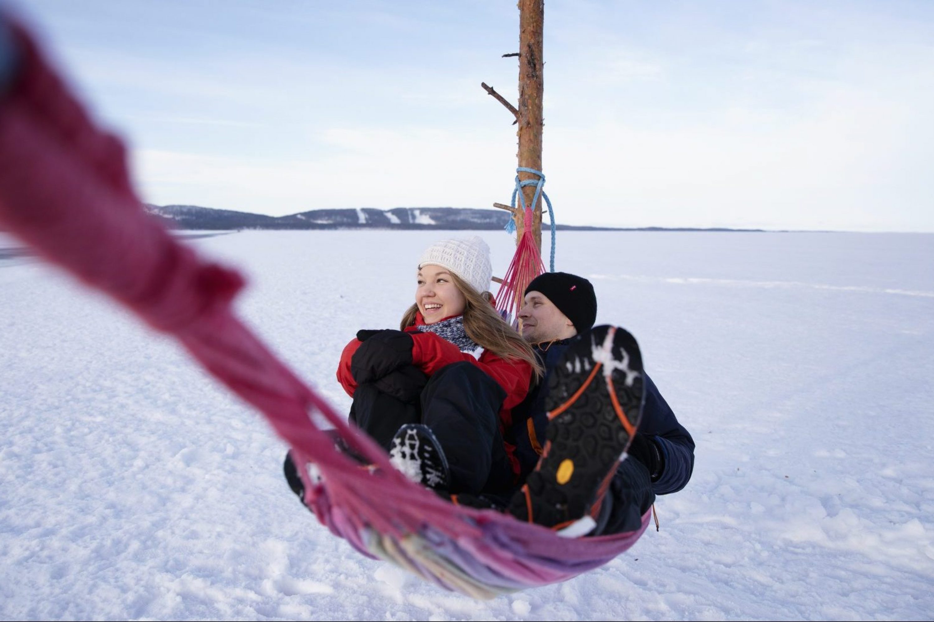 Mies ja nainen vierekkäin riippumatossa Pielisen jäällä