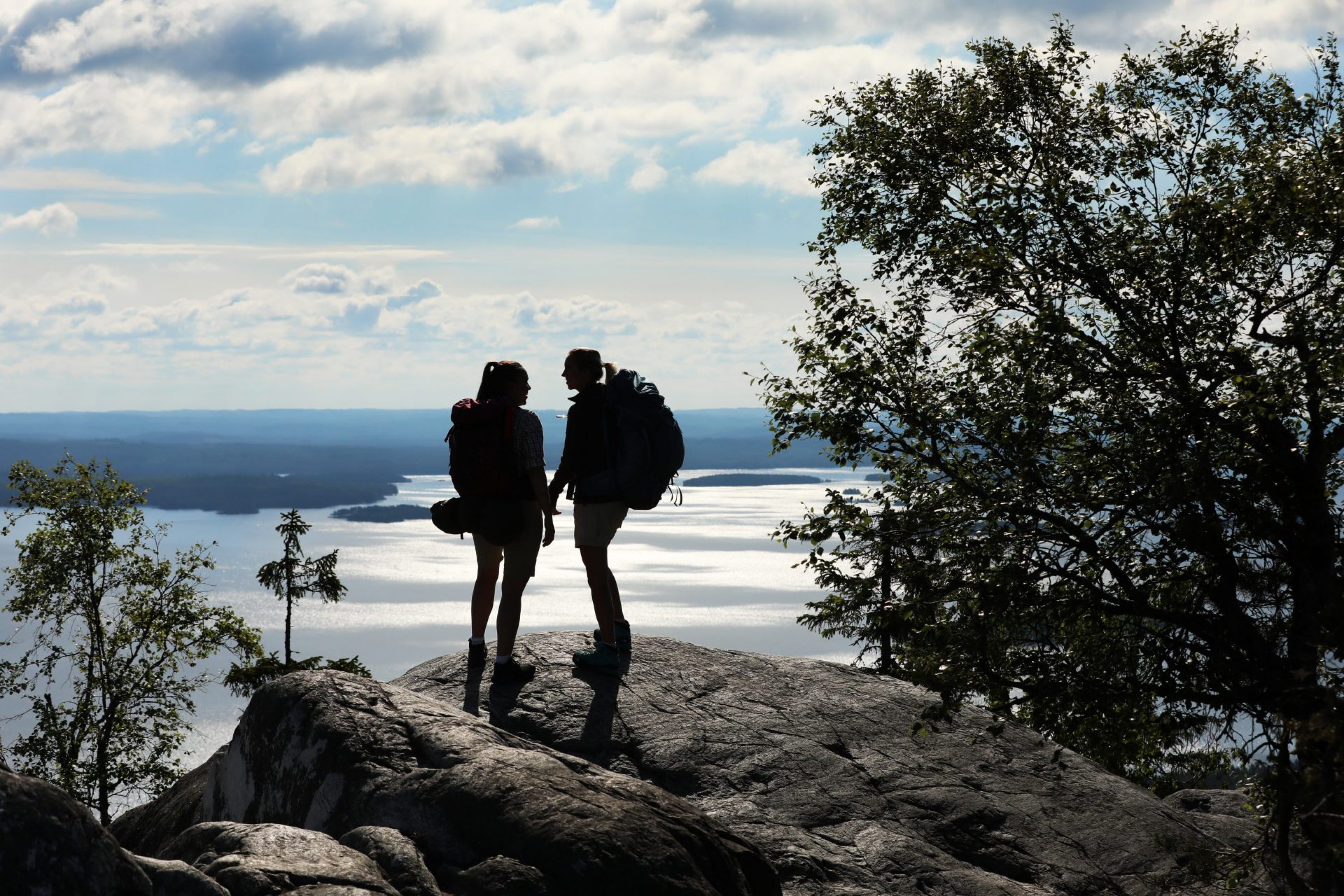 Two silhouettes of hikers on the Koli Hills