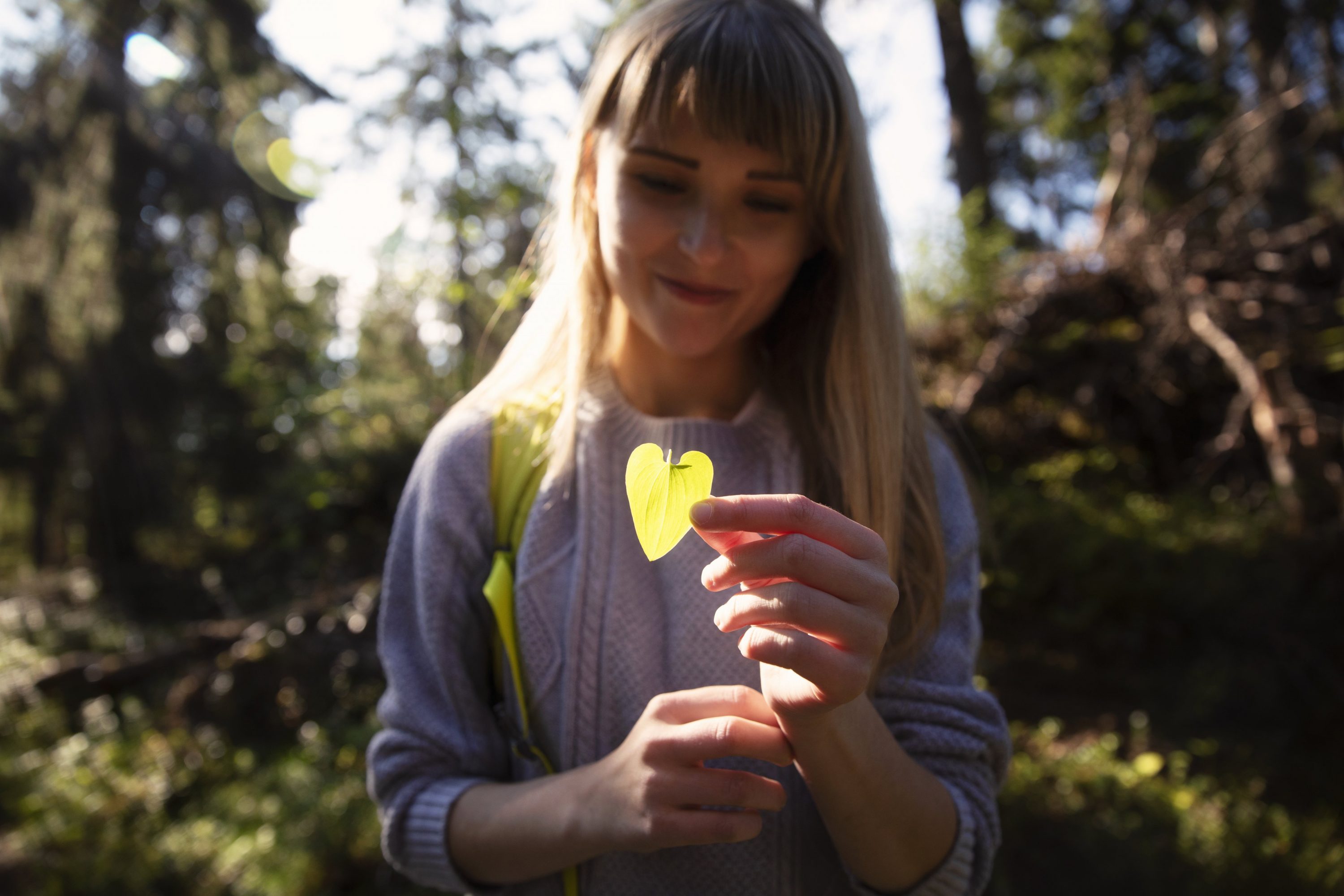 Tyttö pitelee sydämenmuotoista lehteä kädessään