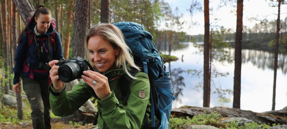 Kaksi naista valokuvaamassa metsässä