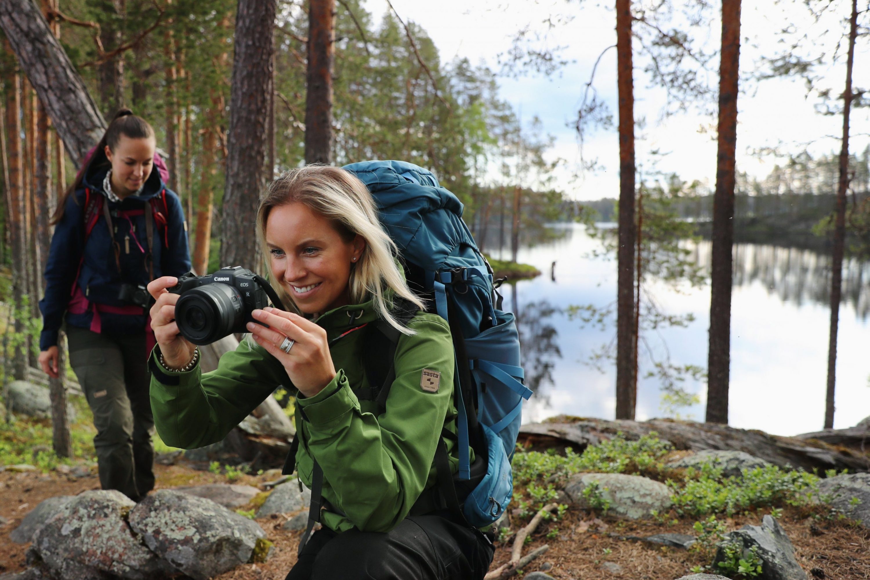 Kaksi naista valokuvaamassa metsässä