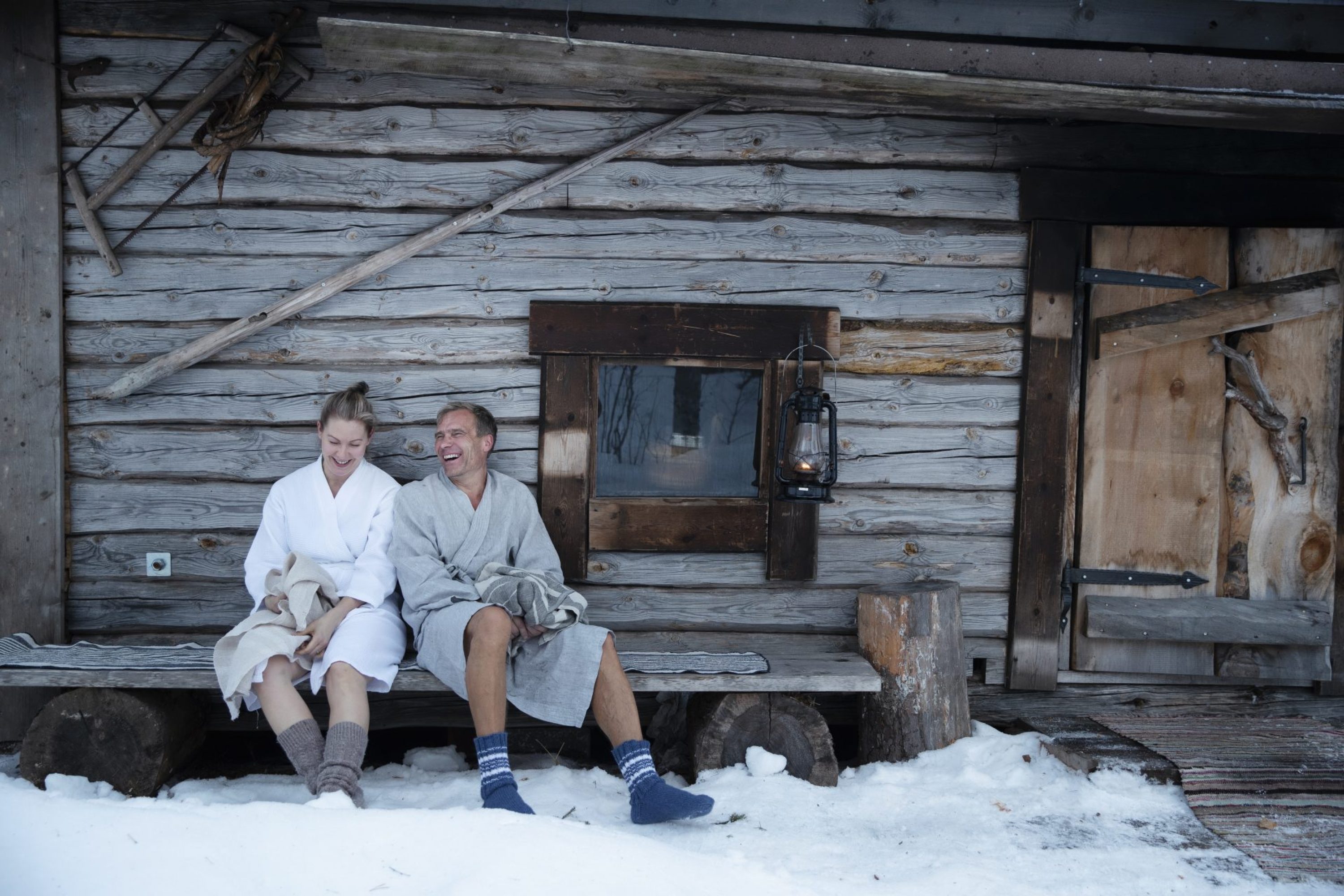 A happy couple sitting in front of the smoke sauna