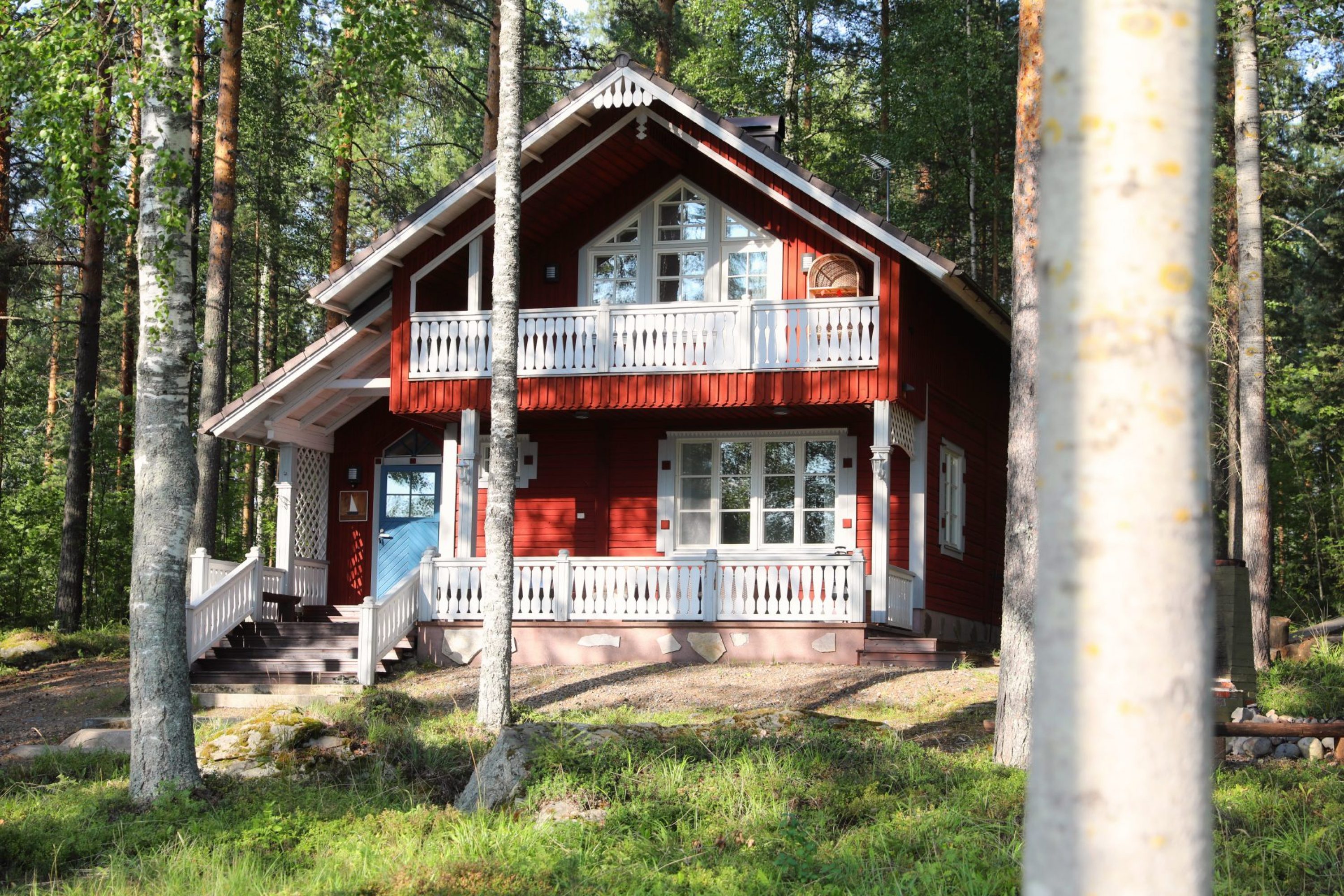 A red summer cottage with blue door