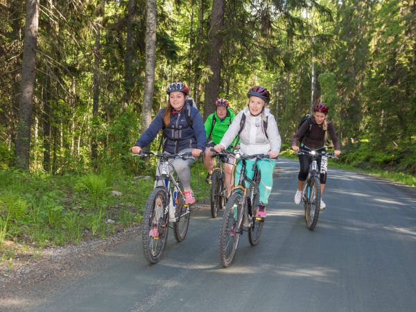 Naiset pyöräilemässä metsätiellä