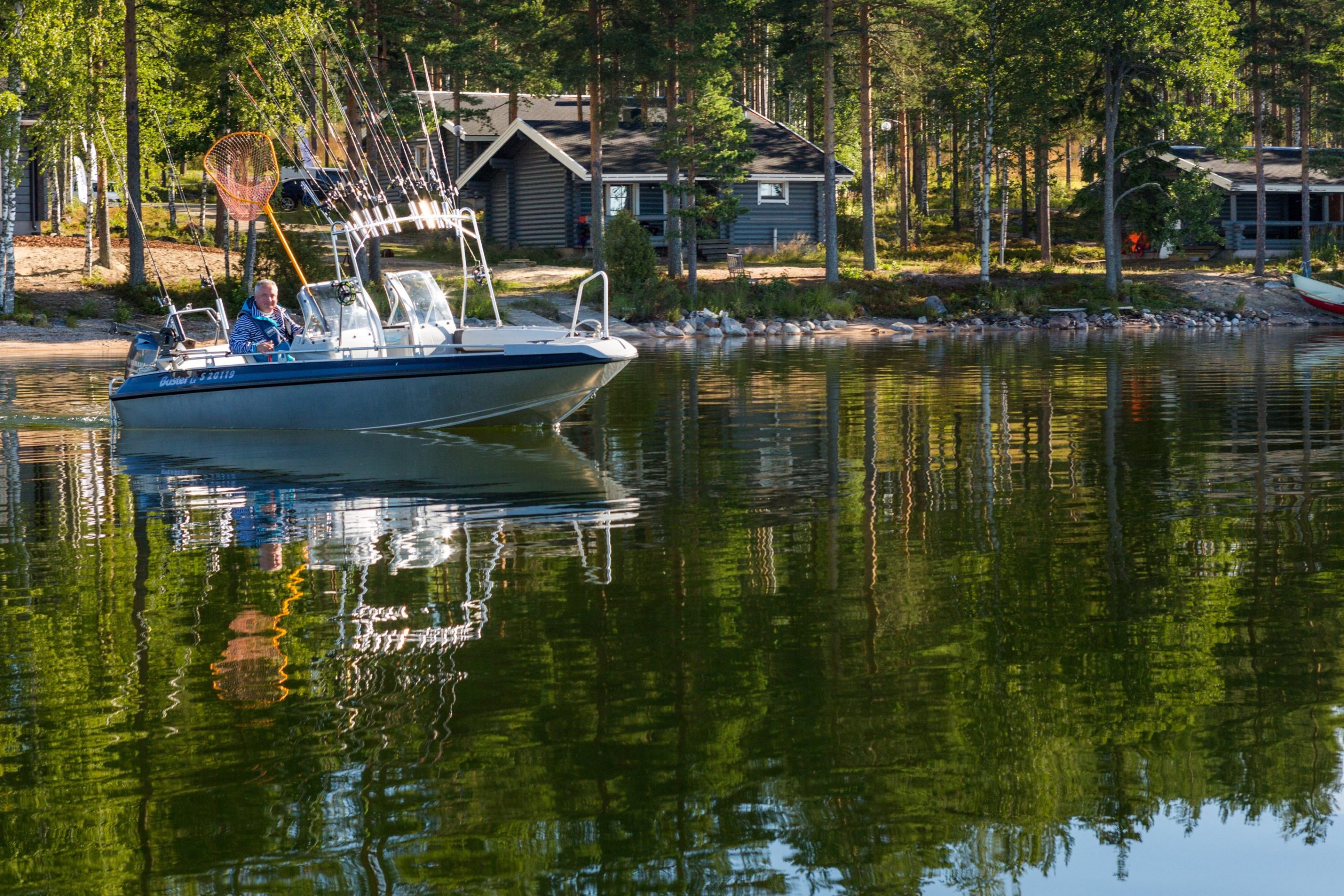 Vene tyynellä järvellä mökkirannassa