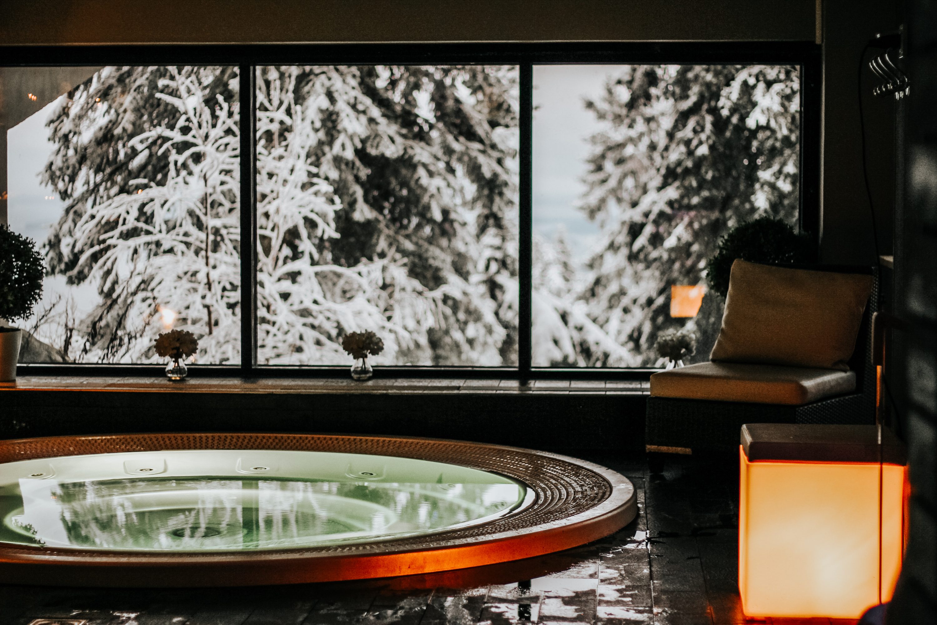 A hot pool with a snowy view