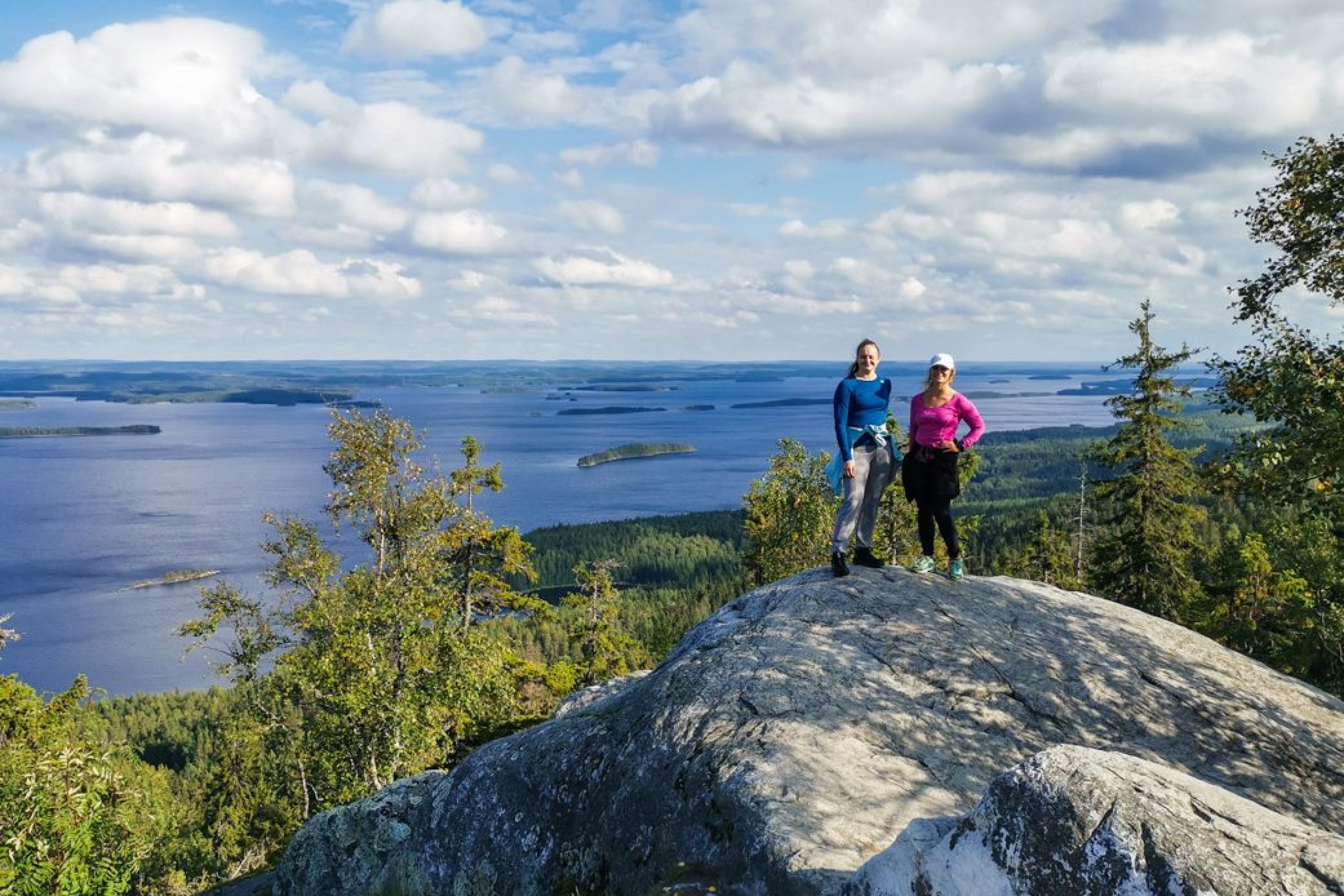 Kaksi naista seisoo vierekkäin Kolin huipulla