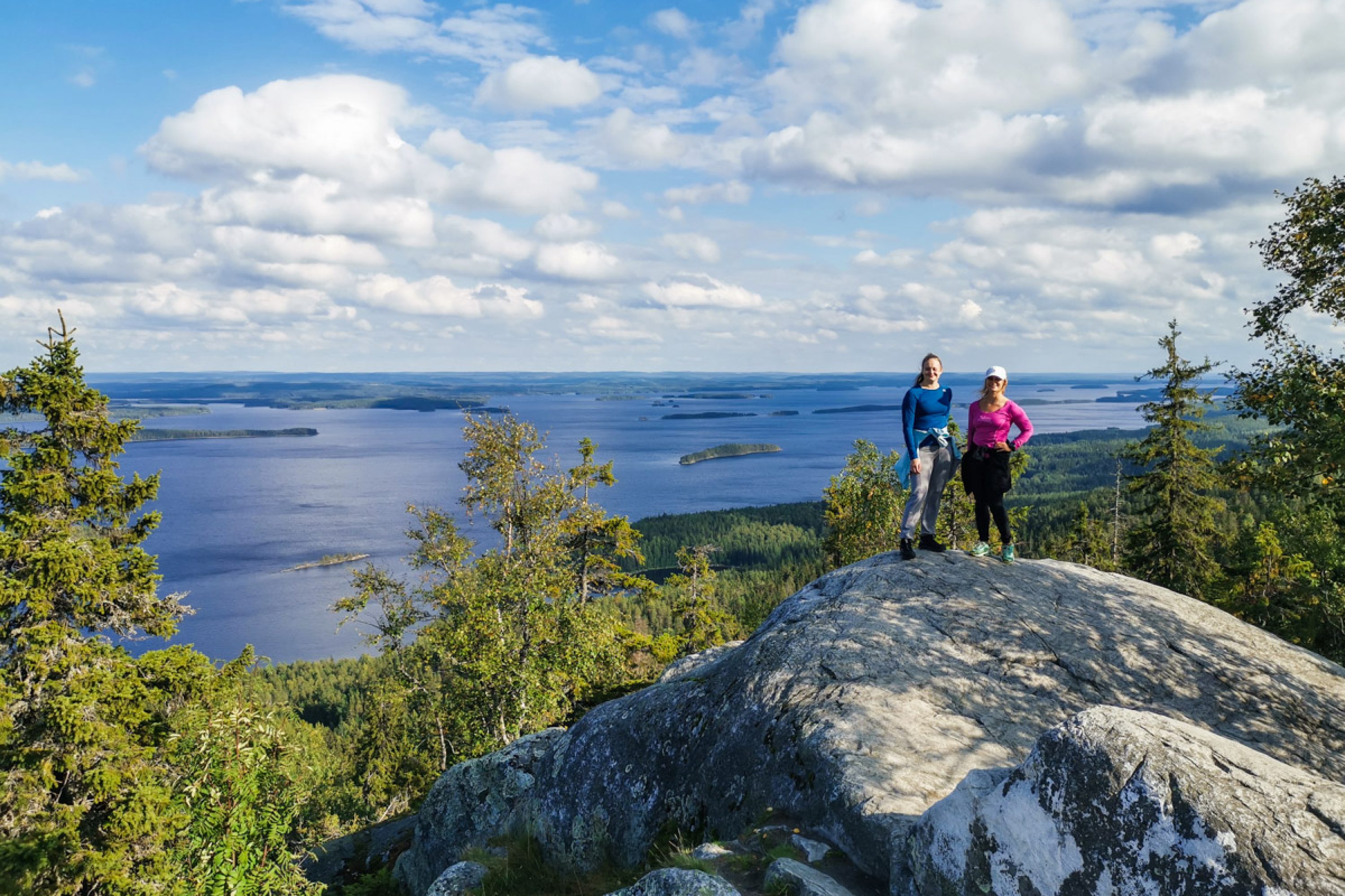 Kaksi naista seisoo vierekkäin Kolin huipulla